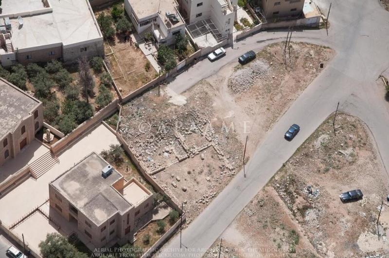Figure 2: This 2013 aerial photograph shows a road over a section of an exposed excavation of the remains of a church in Ma’in, Jordan (APAAME_20130414_MND-0484 Ma’in).